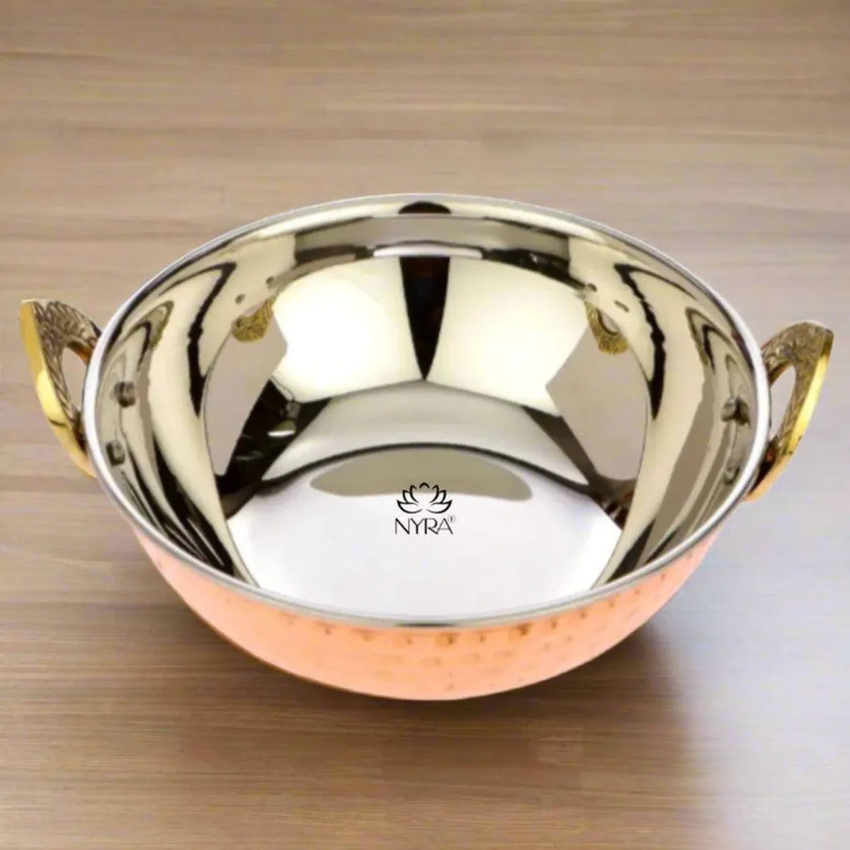 Top view of a copper kadhai showing its shiny stainless steel interior