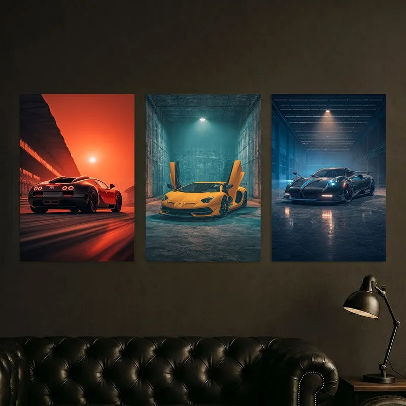 Three automotive posters hung above a dark sofa with a lamp beside it