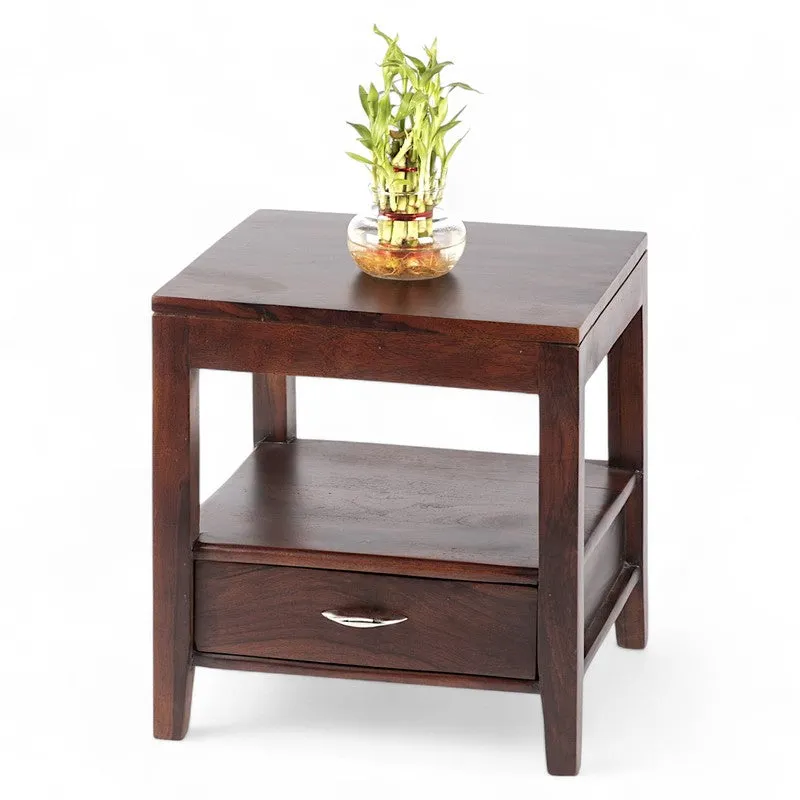 Dark brown wooden bedside table shown at an angle with a plant on top.