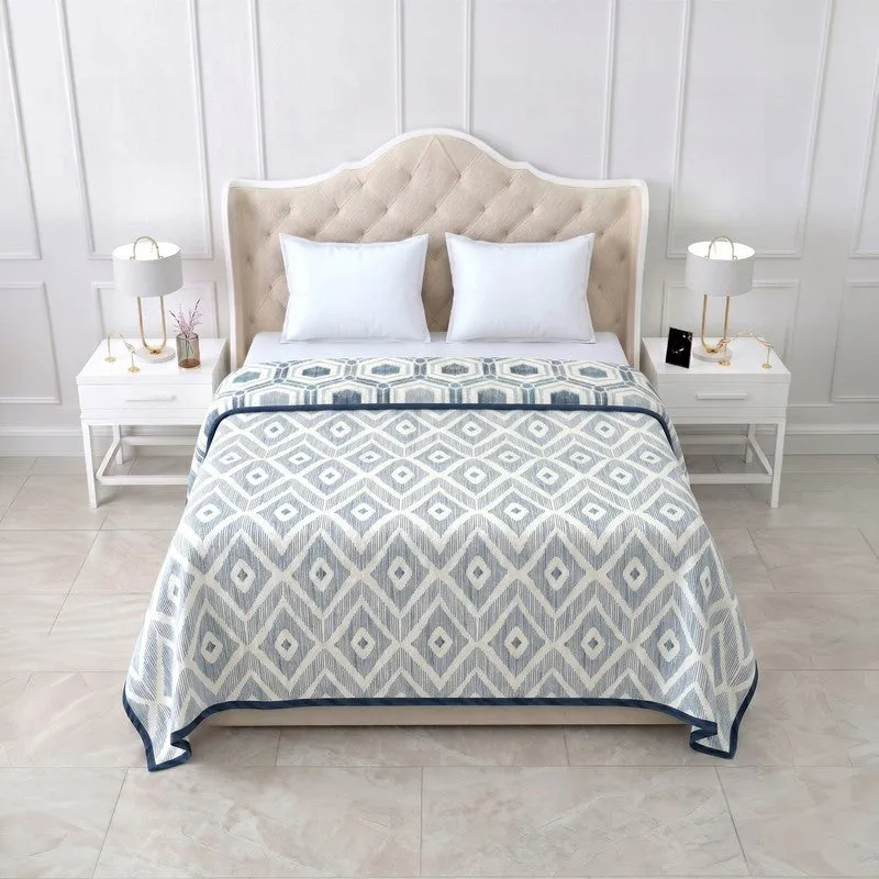 Reverse side of blue and off-white geometric dohar on a bed