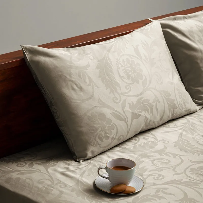 Close-up of beige floral pillow cover on matching bedsheet