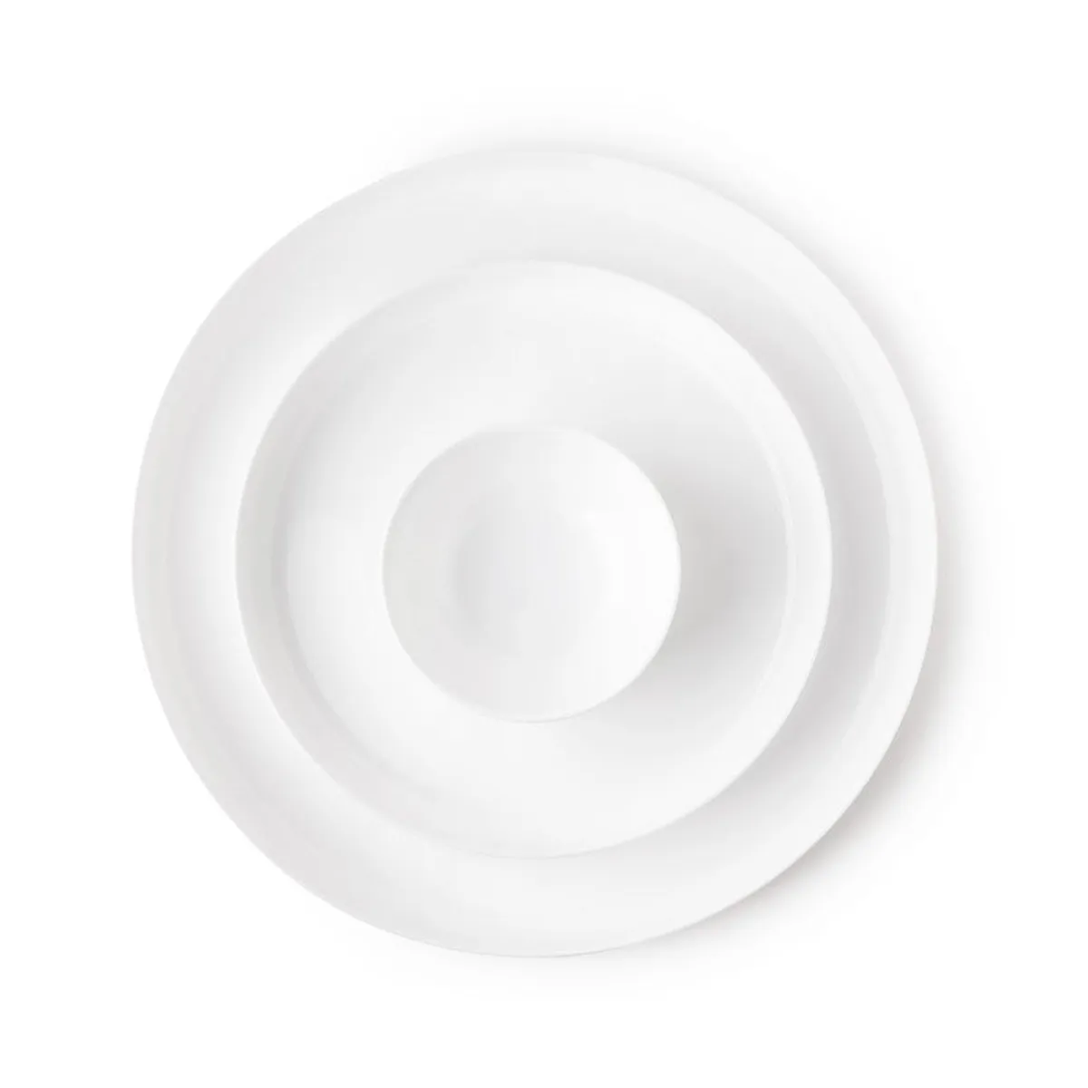 Overhead view of stacked white plates and a bowl