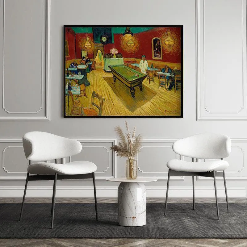 Framed Night Cafe artwork displayed on a white paneled wall between two white chairs.
