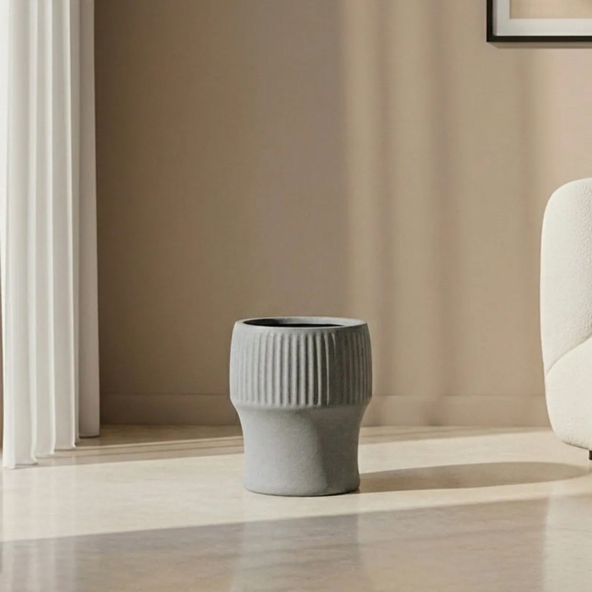 Grey ribbed planter shown empty on a light floor