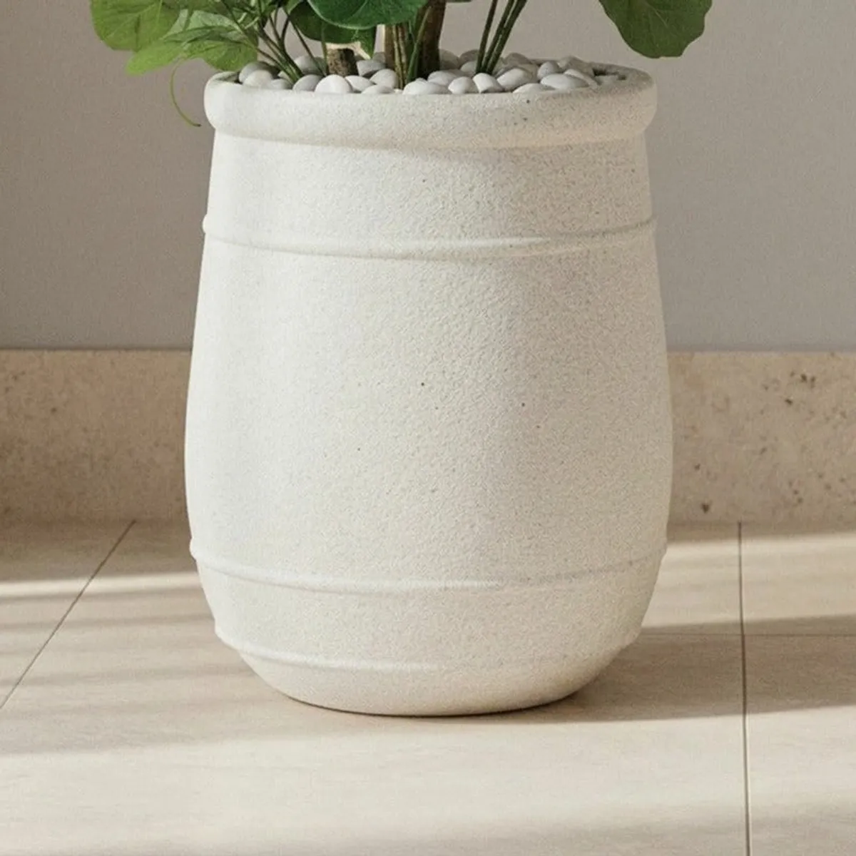 Close-up of the planter's off-white matte surface and rounded lower rim