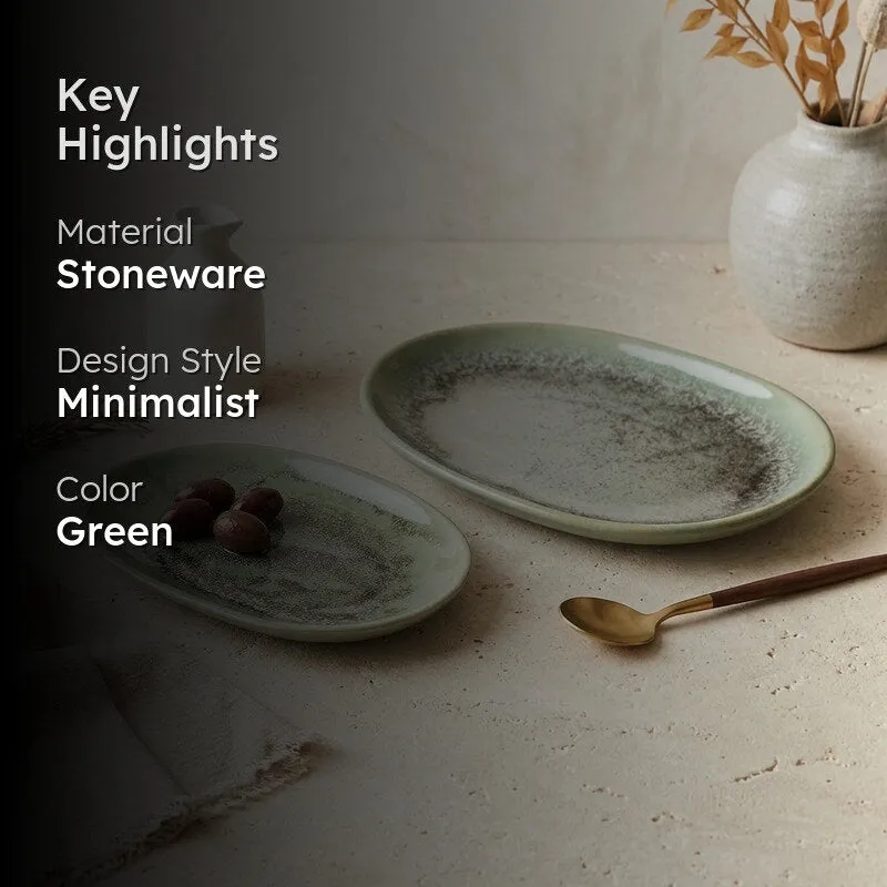 Green oval platter displayed in a neutral dining setting with a vase and spoon