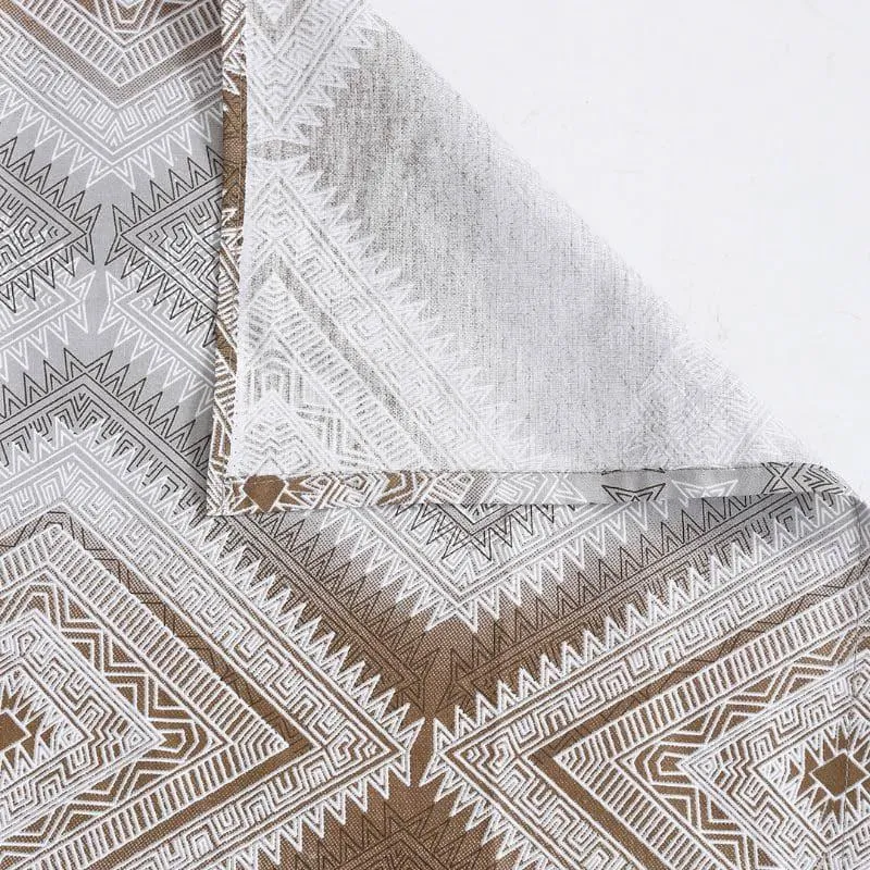 Close-up of brown and grey geometric bedsheet fabric with folded corner