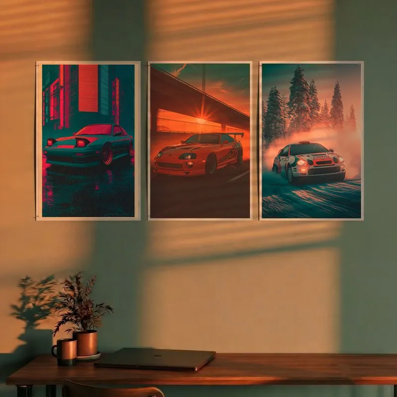 Set of three car posters displayed above a desk in warm light