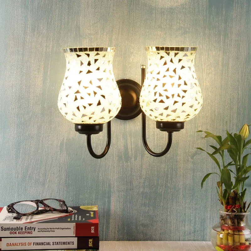 Lit dual wall lamp with patterned glass shades and black iron arm