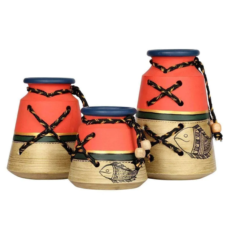 Set of three red and beige urn vases with fish motifs on a white background
