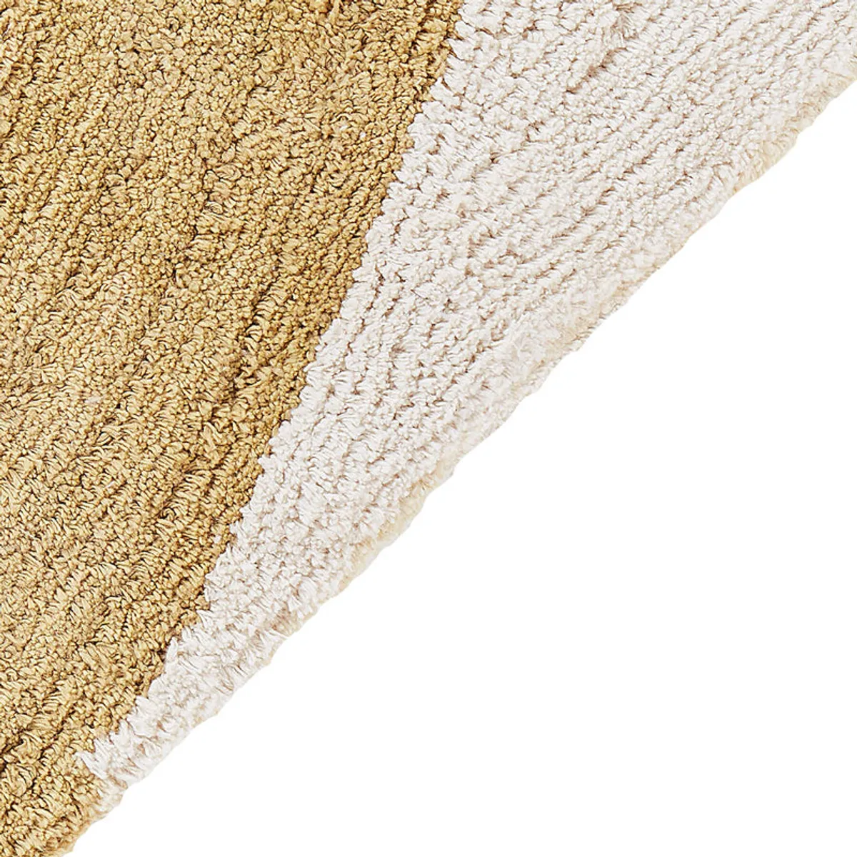 Close-up of the rug's textured cream and gold tufted surface