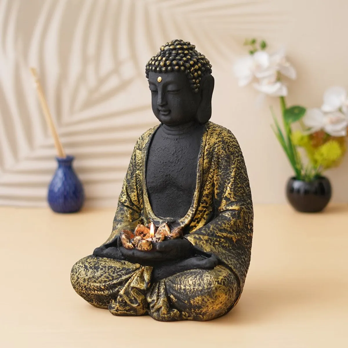 Angled view of a black and gold Buddha tea light candle holder