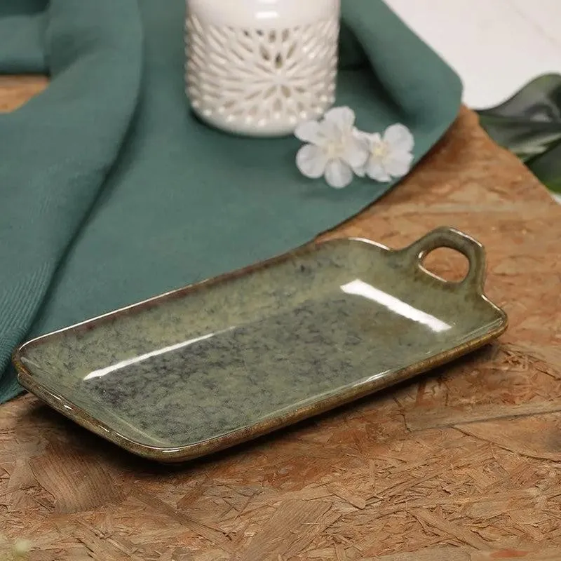 Green ceramic serving platter with handles styled on a wooden table