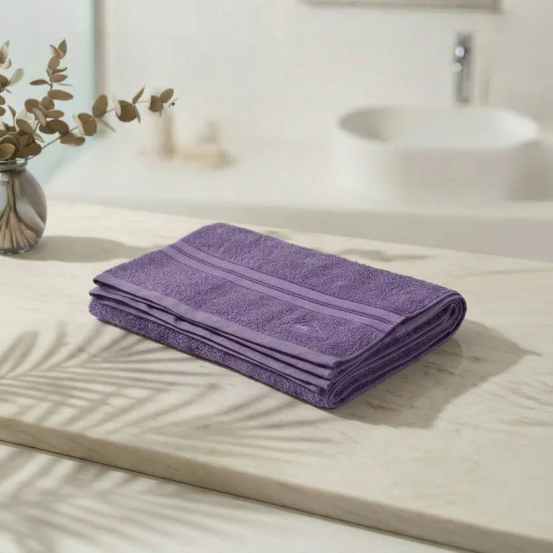 Folded purple bath towel placed on a bathroom counter