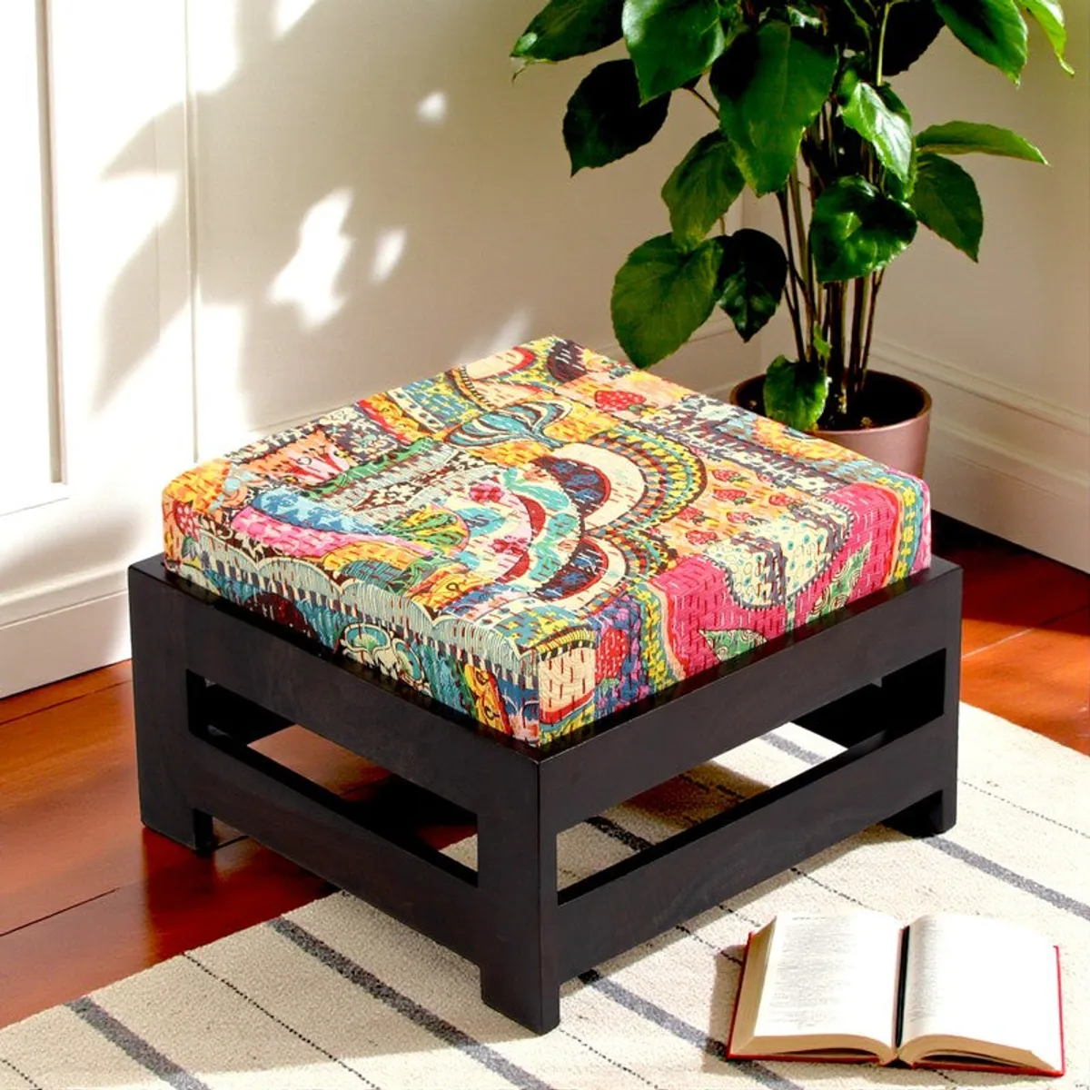 Two dark wooden stools with colourful cushions in a living room
