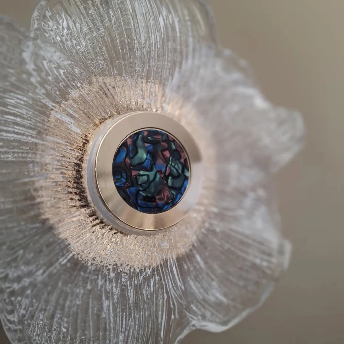 Close-up of textured glass petals and a colourful mosaic-like lamp centre