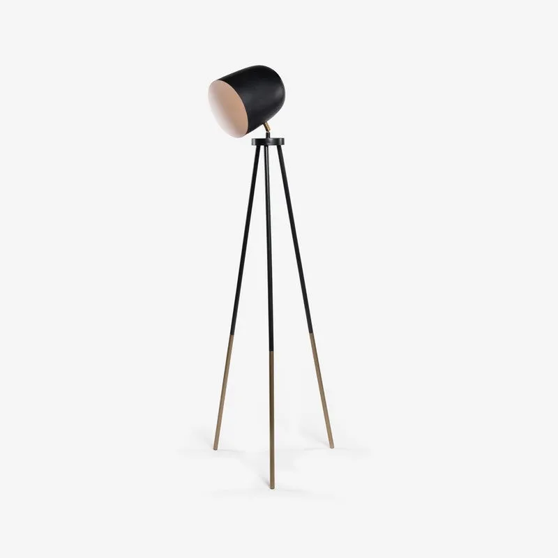 Black tripod floor lamp with metallic leg tips on a light background