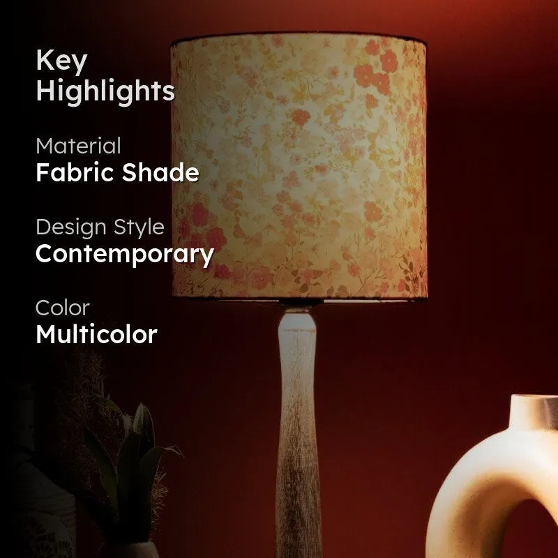 Floral table lamp with fabric shade and wooden pillar base in a styled setting