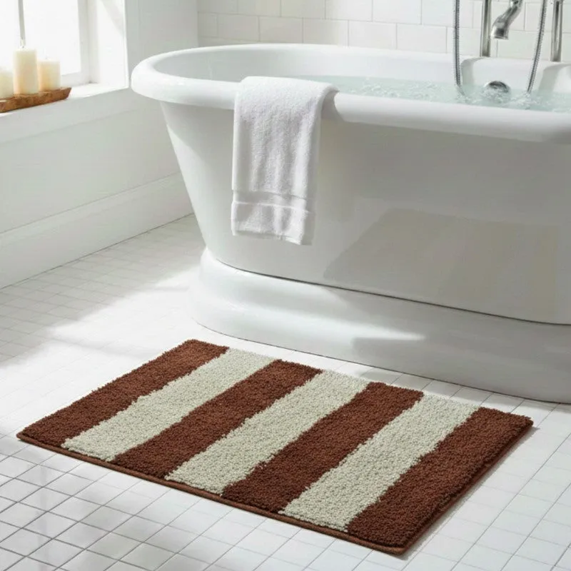 Striped bath mat placed beside a white bathtub