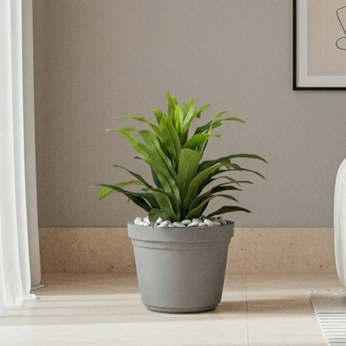 Grey planter holding a leafy green indoor plant in a contemporary room.