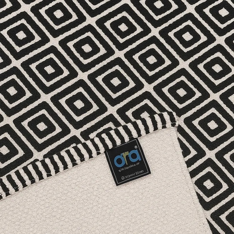 Close-up of black and off-white geometric rug pattern and edge
