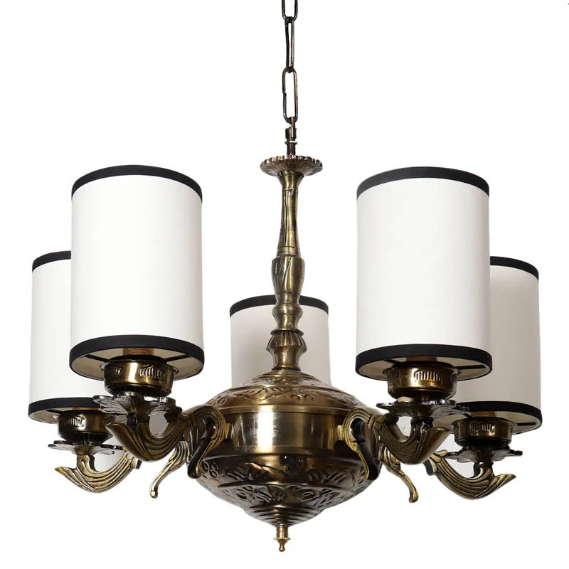 Close-up of antique gold chandelier with white cylindrical shades