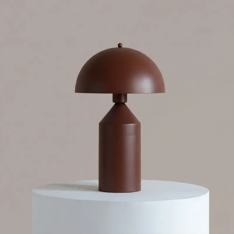 Front view of a brown dome-shaped metal table lamp on a white pedestal