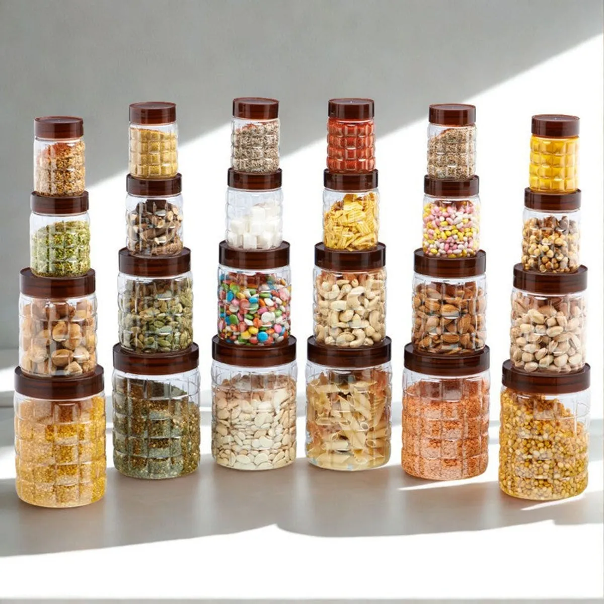 Brown-lidded transparent storage containers arranged in rows against a bright neutral background.