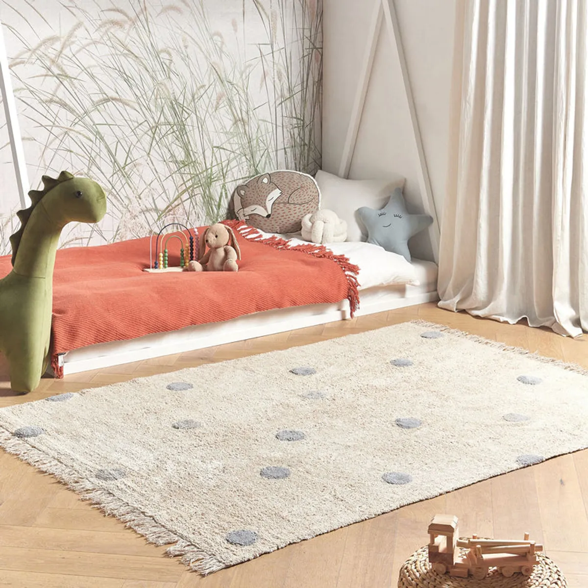 Polka dot cotton rug styled in a bright children's room with a bed and toys