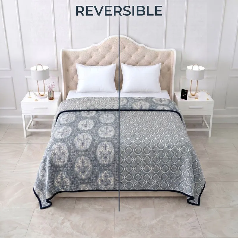 Reversible blue dohar displayed on a bed with both printed sides visible