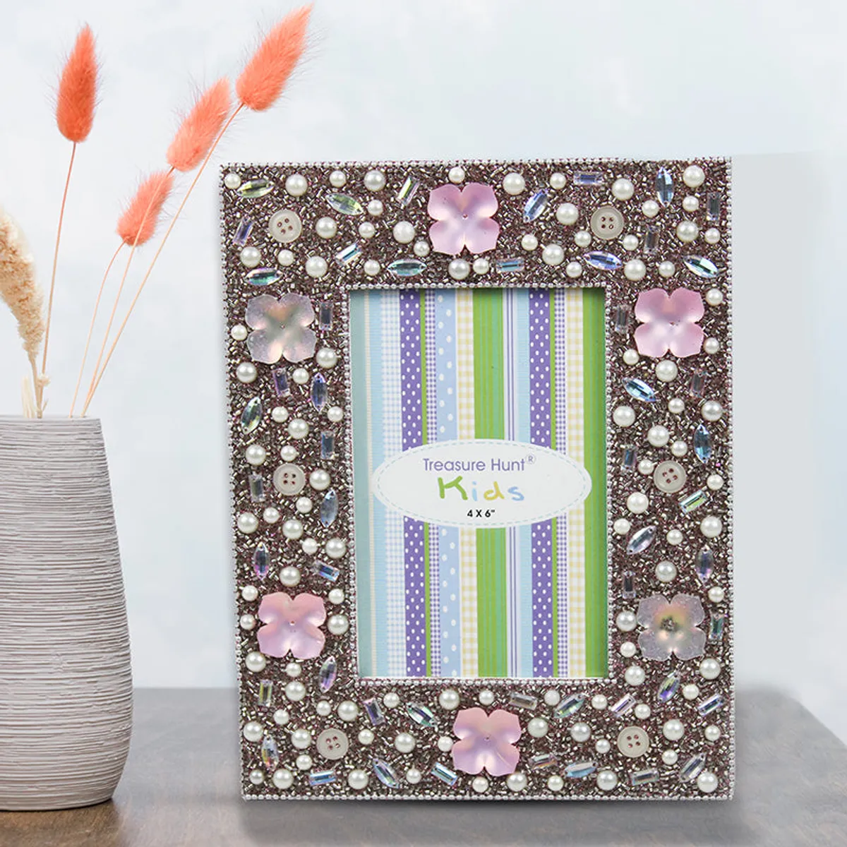 Decorative multicolour photo frame displayed beside a vase with dried flowers.