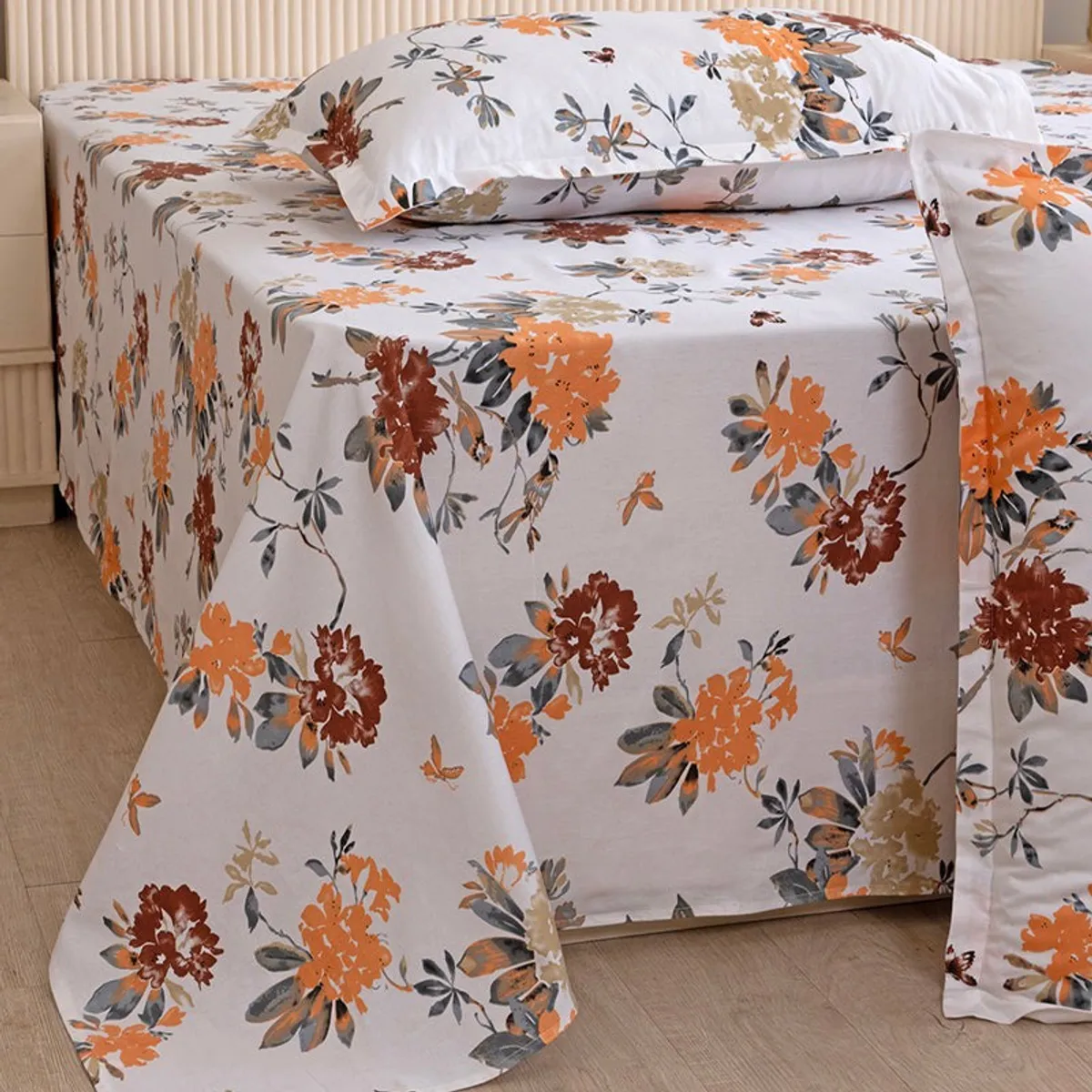 Close-up of white floral bedsheet draped over bed edge