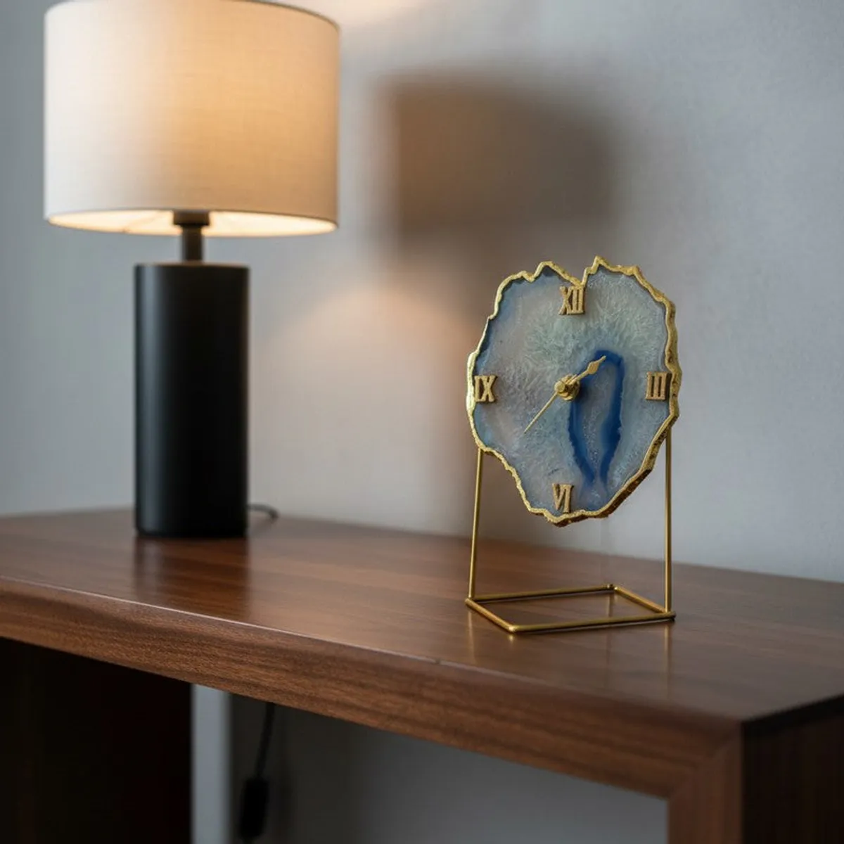 Blue agate table clock displayed on a dark wood console beside a lamp