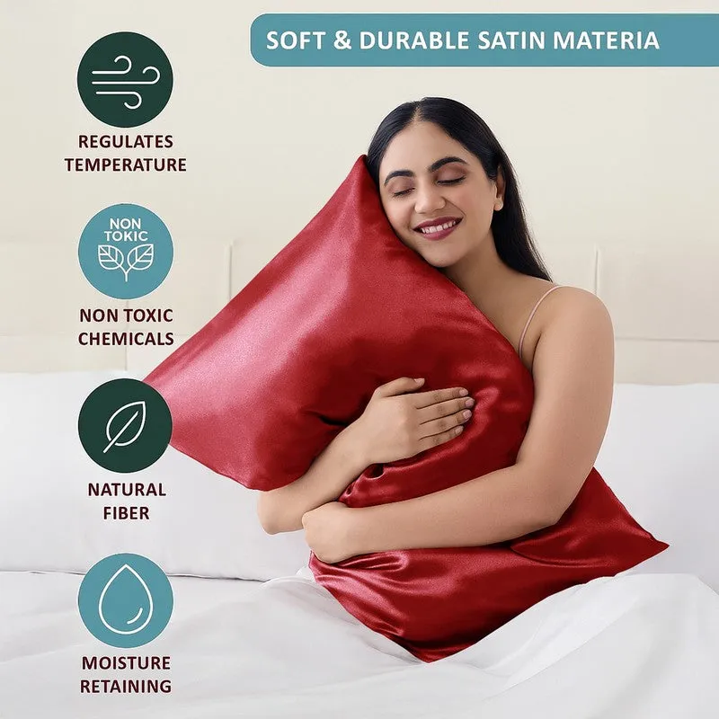Person holding a red satin pillow cover in a bedroom