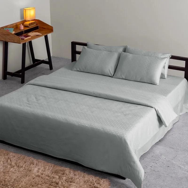 Light grey geometric duvet cover styled on a bed in a modern bedroom
