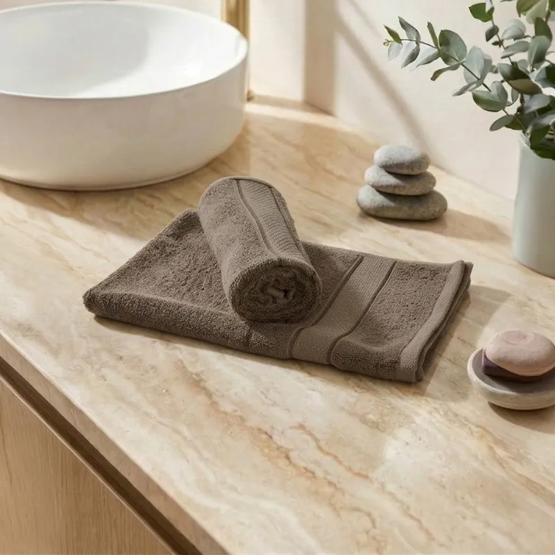 Grey hand towels placed on a bathroom counter near a basin