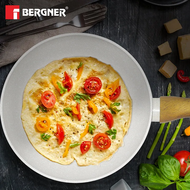 White speckled frying pan holding an omelette with vegetables