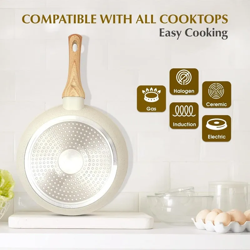Underside of white frying pan with wood-look handle standing upright