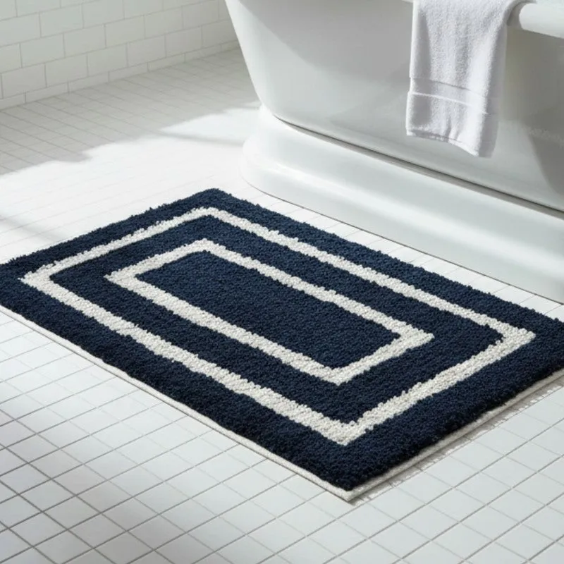 Blue and white geometric bath mat placed beside a modern bathtub