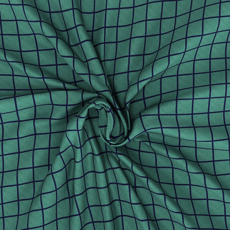 Green and blue grid-patterned bedsheet gathered to show its drape