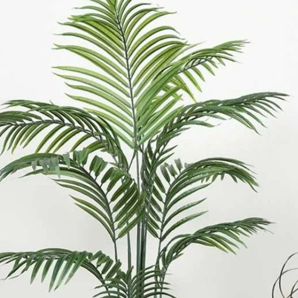 Close-up view of layered green fronds on an artificial Arica palm