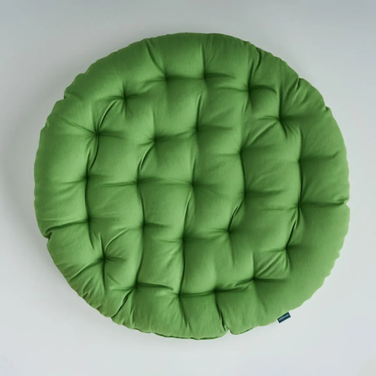 Top view of a round light green tufted floor cushion