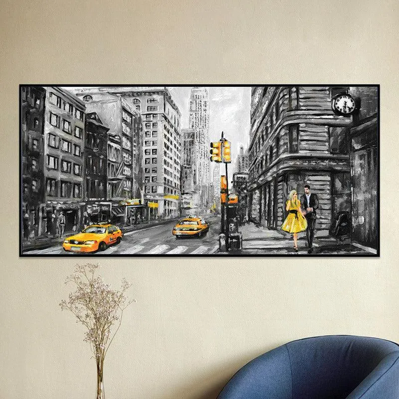 Panoramic framed city street artwork with yellow accents displayed above a chair