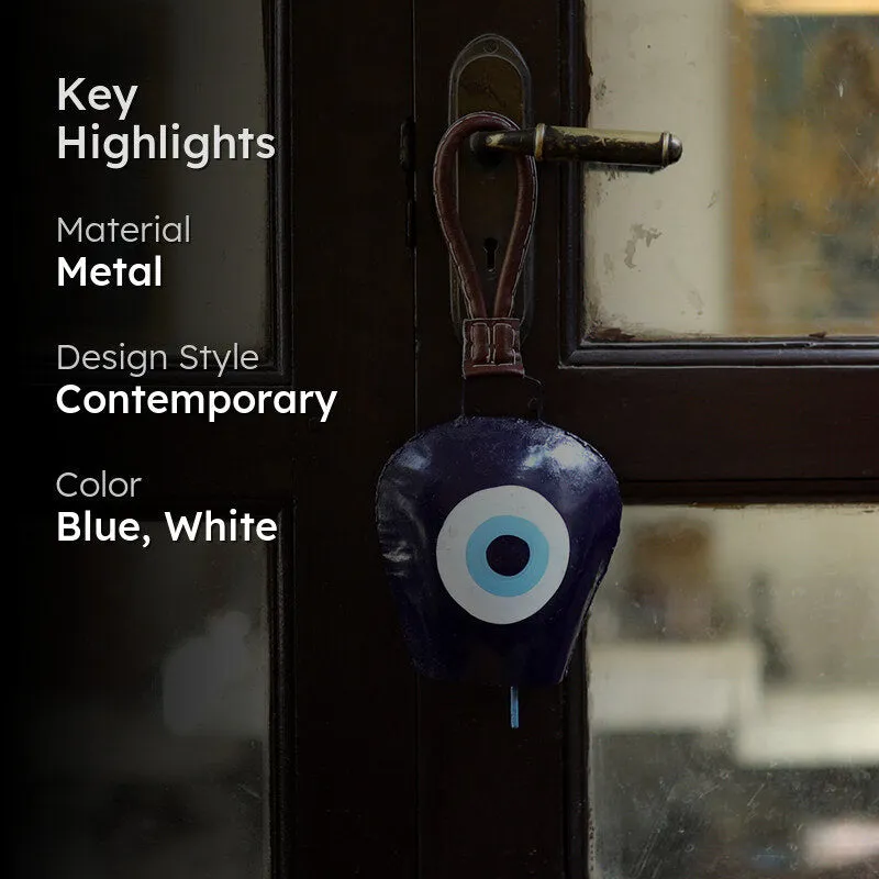 Metal hanging bell displayed on a door with blue and white eye motif