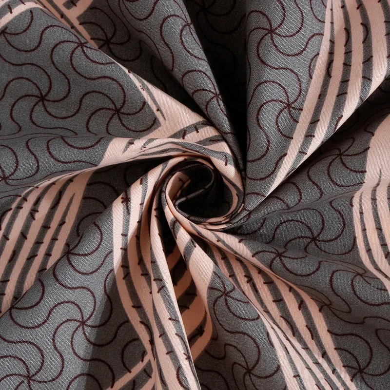 Fabric close-up of grey bedsheet with abstract peach swirls