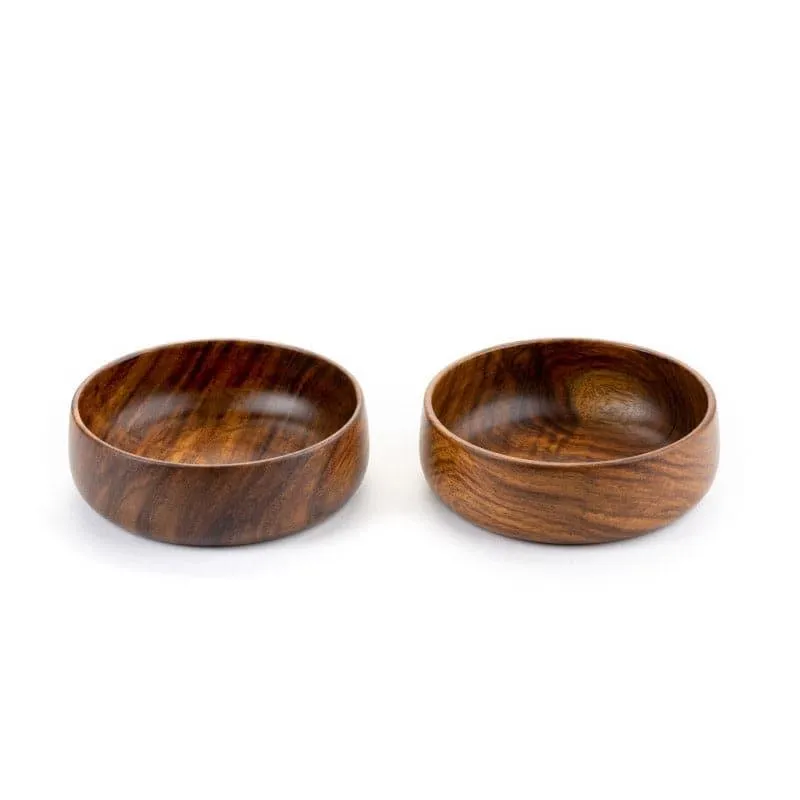 Two round brown wooden serving bowls with visible natural grain