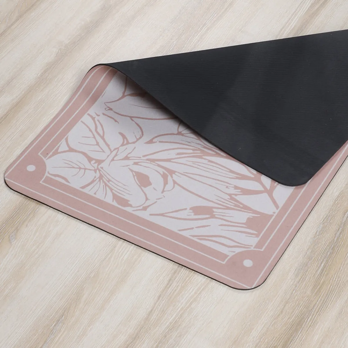 Close-up of the bath mat showing its floral surface and black backing.