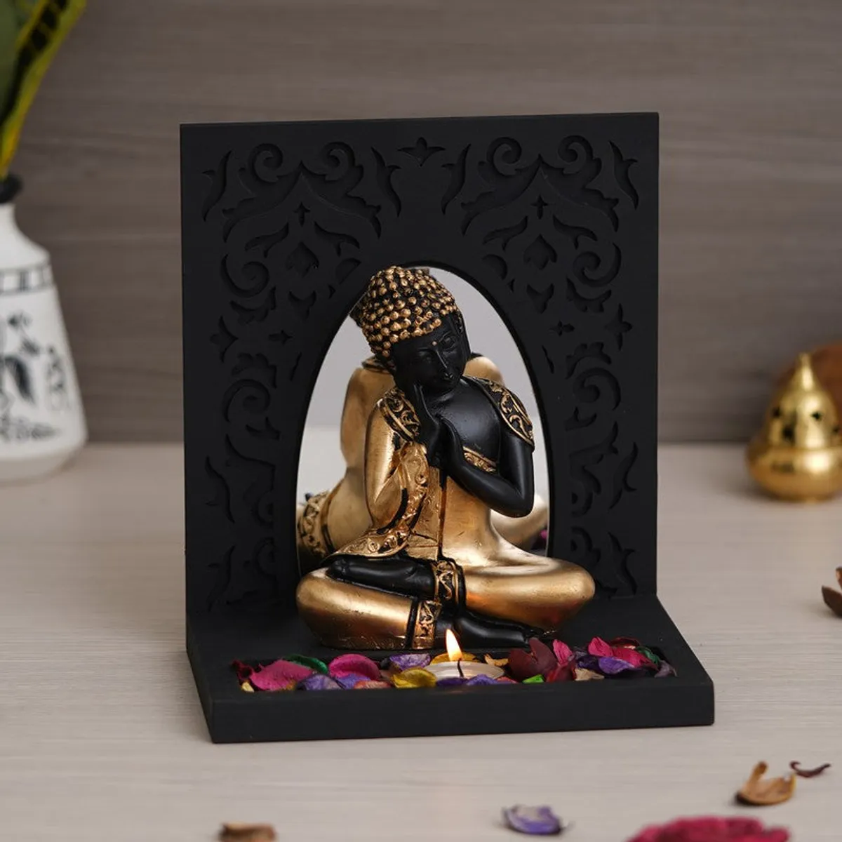 Front view of black and gold Buddha tea light candle holder with arch back panel
