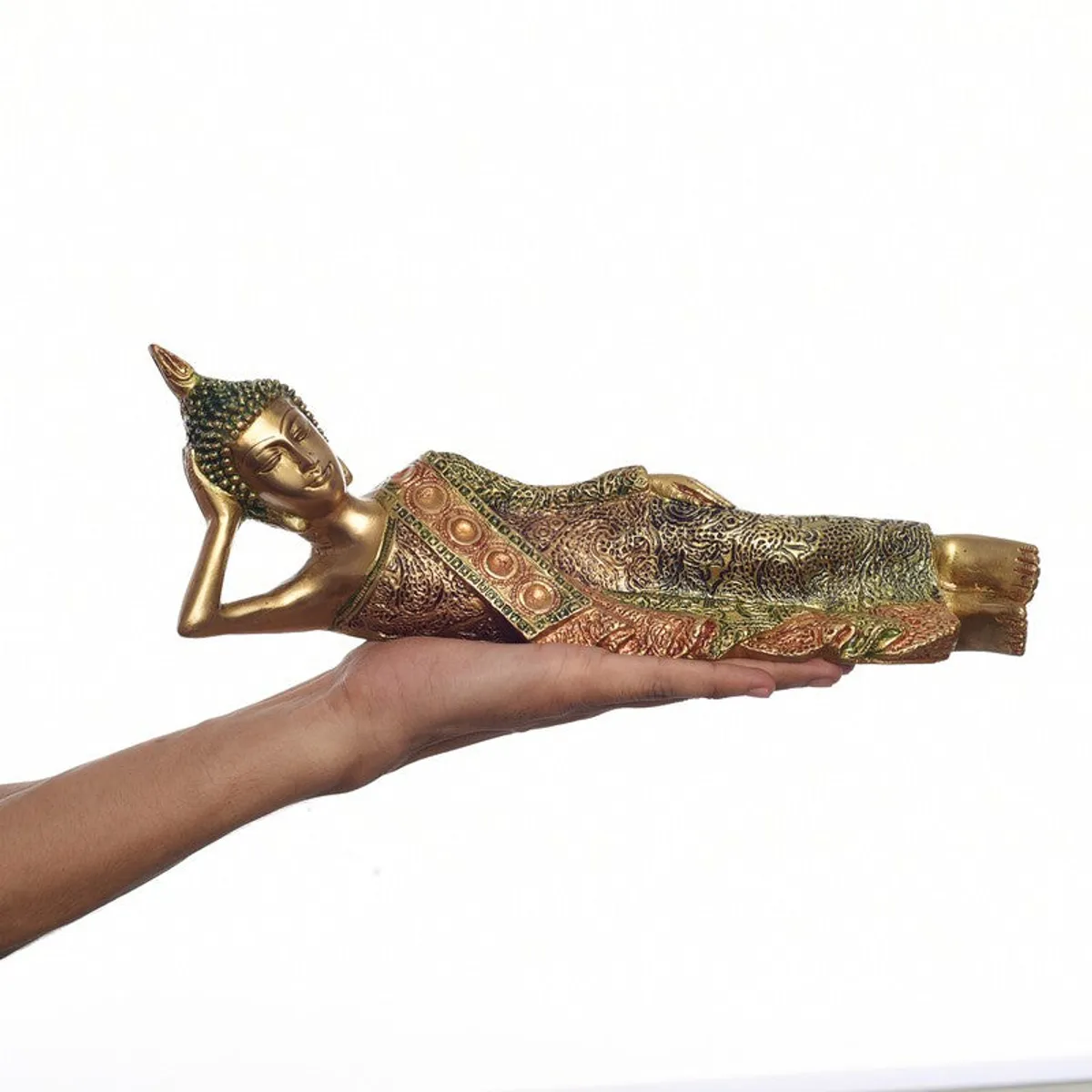Reclining Buddha idol shown resting on a person's hand