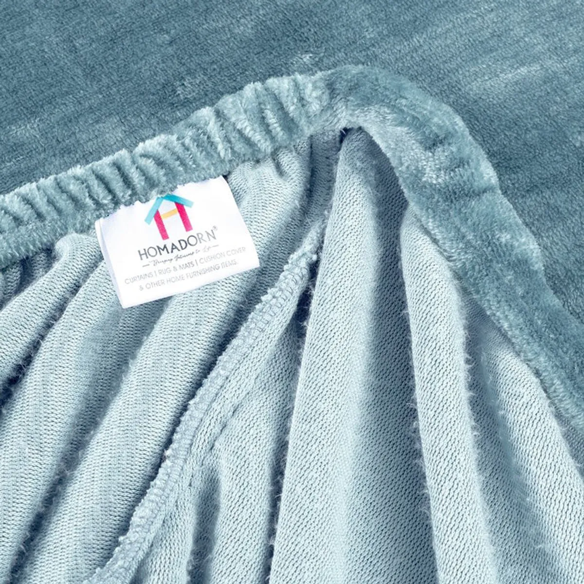 Close-up of the elasticated edge on the sky blue velvet fitted bedsheet